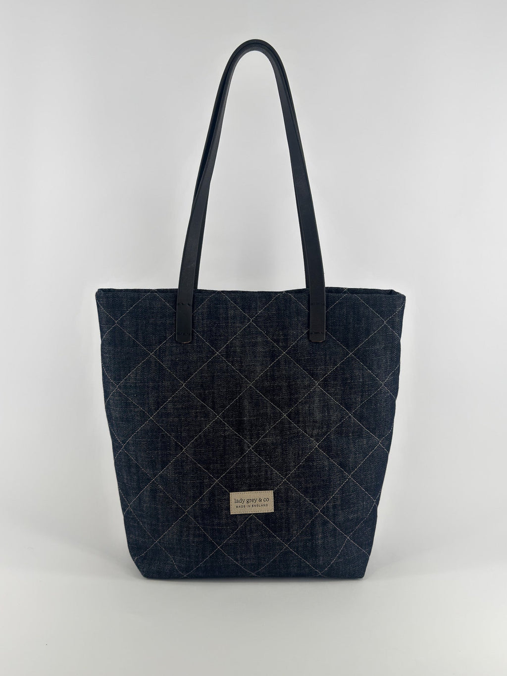 Quilted denim tote bag on a white background